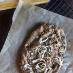 Low-carb focaccia bread on a parchment paper on top of a cooling rack.