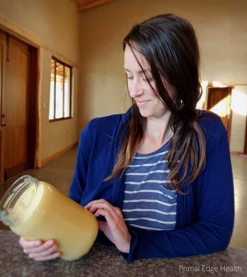 A woman holding a jar of grass-fed beef tallow.