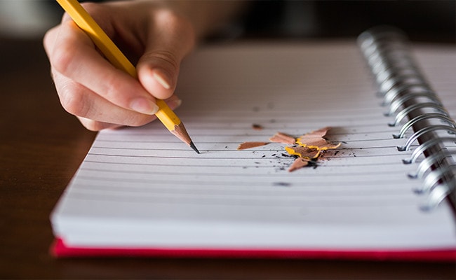 A person writing something on a notebook.