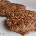 Three burger patties on a plate.