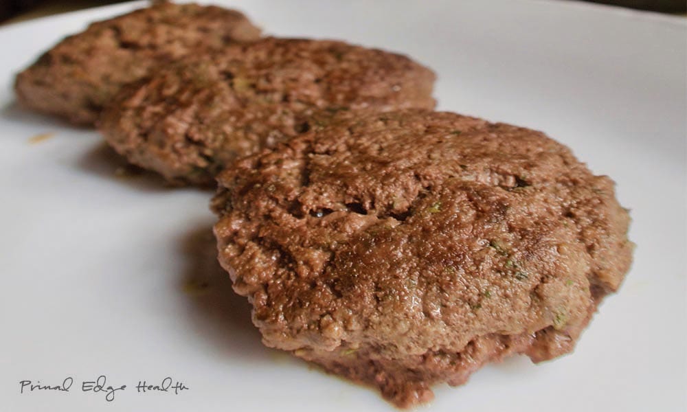 Three burger patties on a plate.