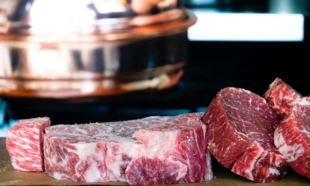 A batch of uncooked meat on a brown surface.