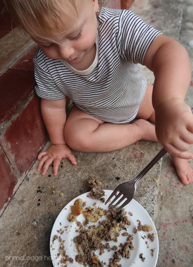 A child enjoying a plate of kid-friendly beef heart meatza.