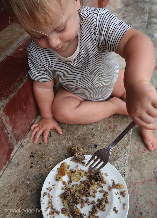 A child enjoying a plate of kid-friendly beef heart keto meatza.