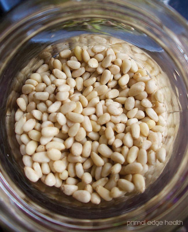 Pine nuts in a clear glass jar.
