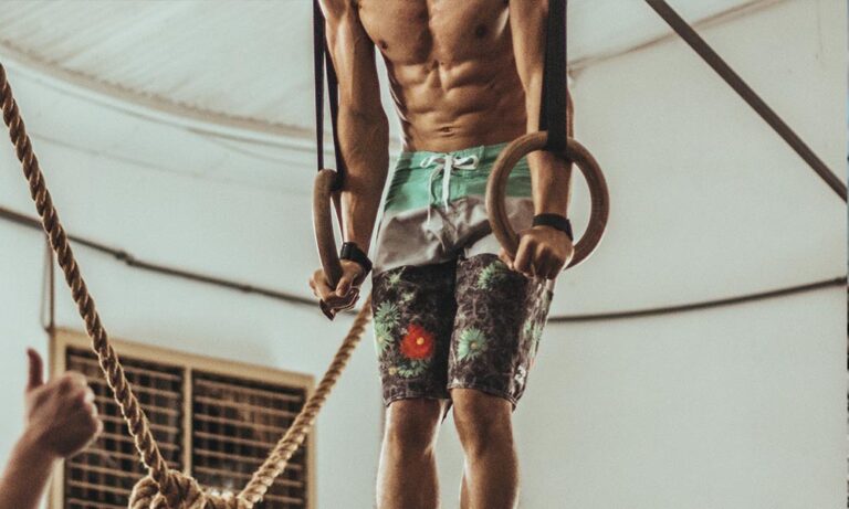A man doing exercise with a hanging exercise equipment.