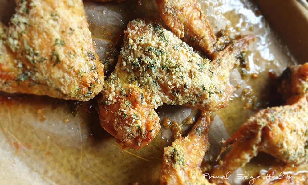 Keto baked chicken wings with herb coating on a plate.