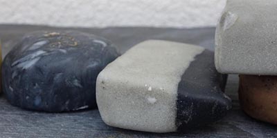 A group of different colored cold process soaps on a table.