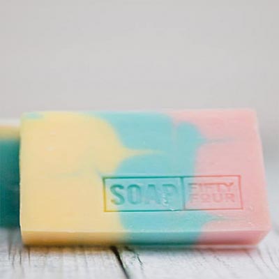 A pink, yellow, and blue cold-process soap bar.