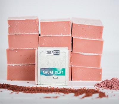 A Pink bar of soap featuring pink powder on top, created through cold-process soap making.