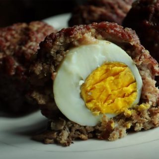 Keto scotch eggs with ground beef, one cut in half.