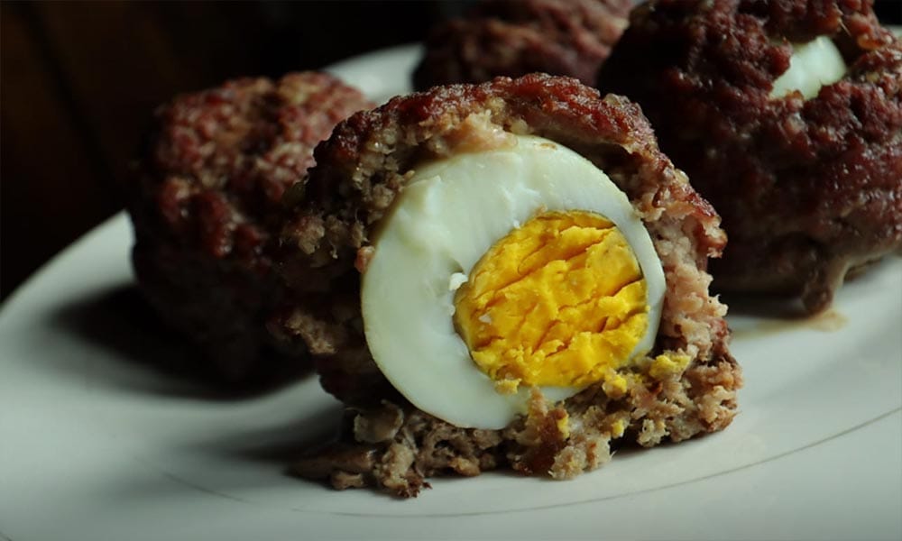 Keto scotch eggs with ground beef, one cut in half.