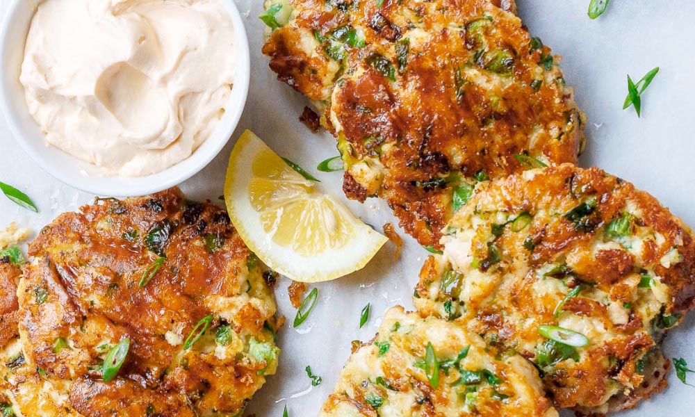 Keto fritter with lemon wedges and dipping sauce.