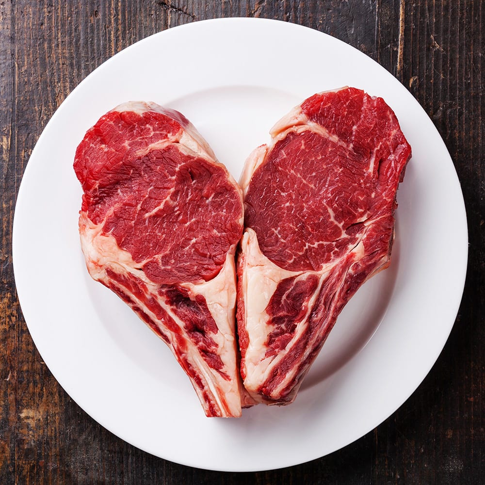 Keto-friendly heart shaped steaks on a white plate.