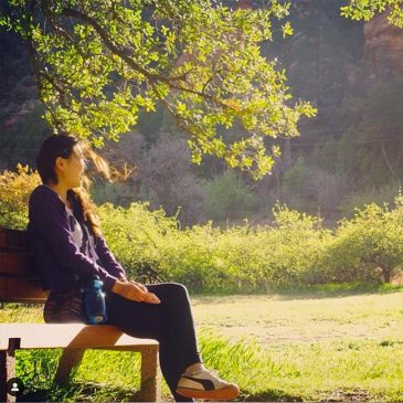 A woman sitting outdoor enjoying the nature.