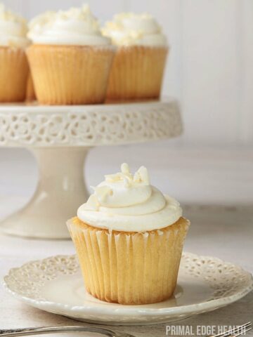 Vanilla cupcake on a plate and a couple on a cupcake stand.