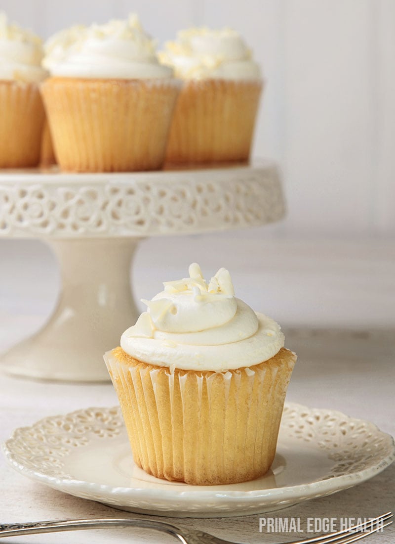 Vanilla cupcake on a plate and a couple on a cupcake stand.