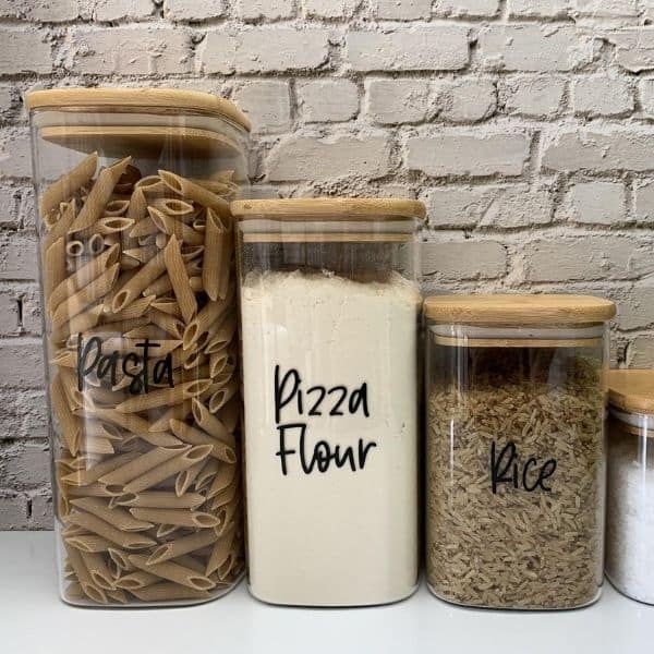 Labelled food containers on a white surface.