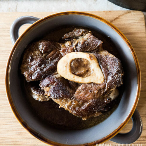 Braised Beef Shank with bone marrow in a ceramic dish.