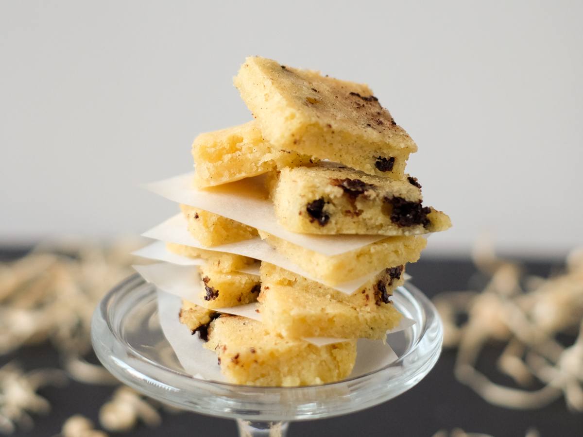 A stack of keto chocolate chip cookie bars on a glass plate.