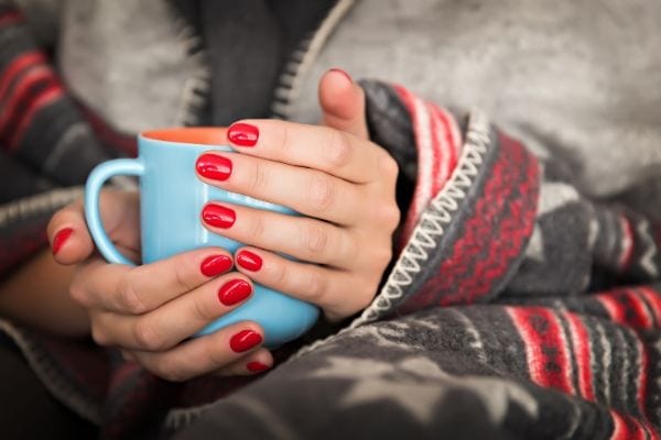 A woman holding a blue cup.