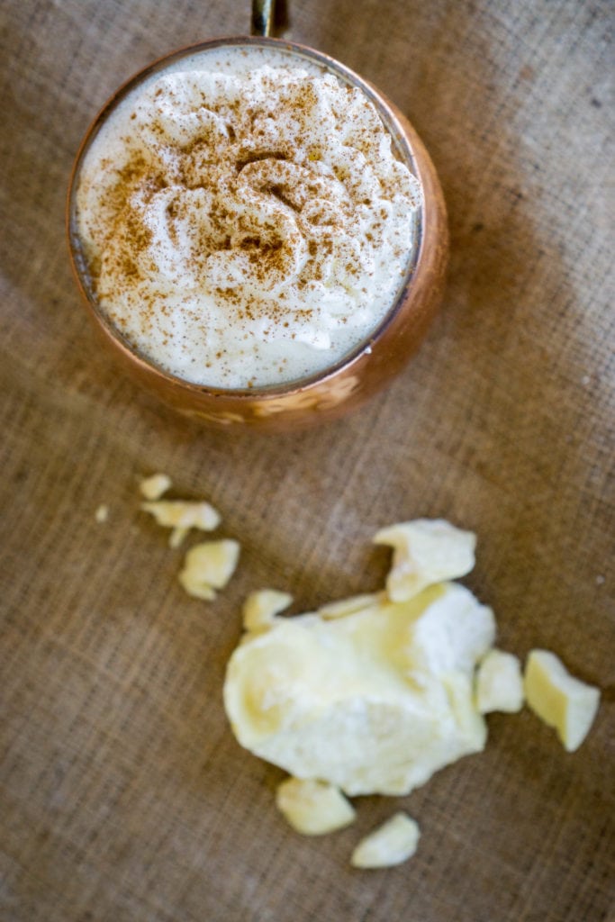 A mug with whipped cream and cacao butter on it.