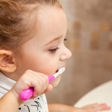 A little girl brushing her teeth.