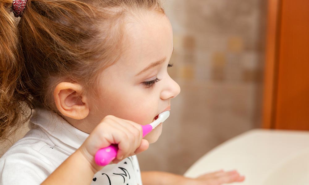 A little girl brushing her teeth.