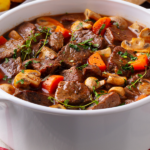 Low-carb beef stew in a pot on a white cloth.