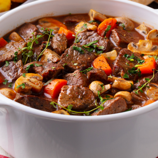 Low-carb beef stew in a pot on a white cloth.