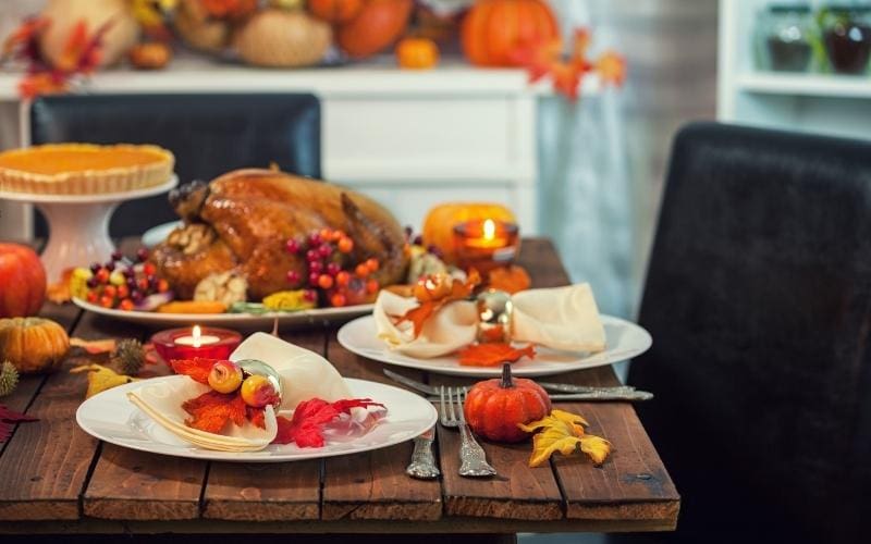Thanksgiving dinner table set with turkey.