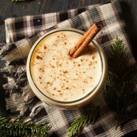 Eggnog recipe keto in a glass on a wooden surface with a cloth.