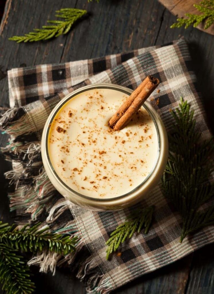 Eggnog recipe keto in a glass on a wooden surface with a cloth.