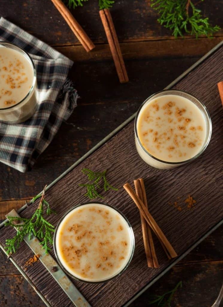 3 servings of keto eggnog non alcoholic on a wooden surface.