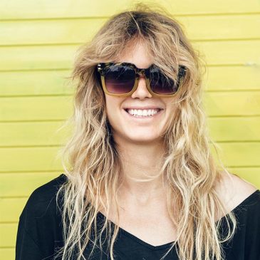 A picture of a blonde woman on a yellow background.