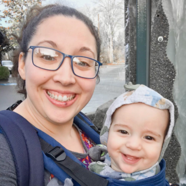 A woman holding a baby in a sling.