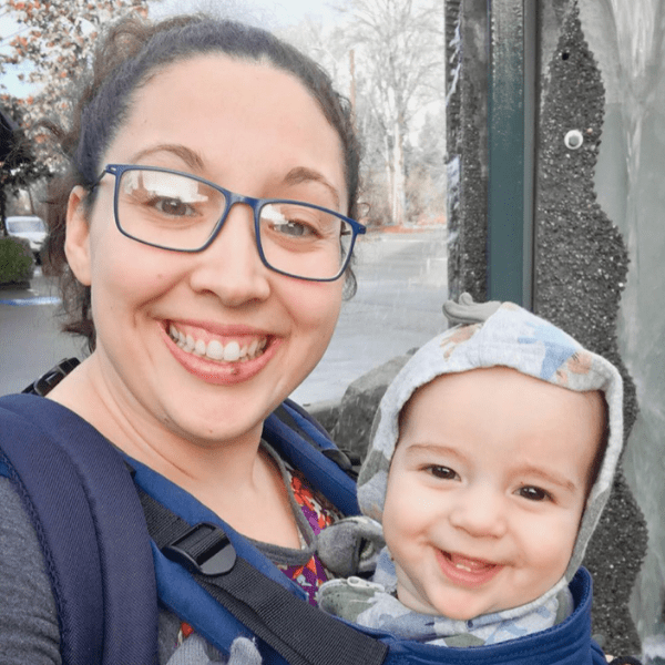 A woman holding a baby in a sling.