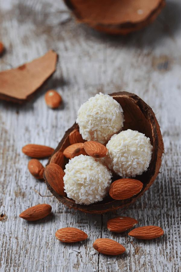 No-bake coconut keto fat bomb garnished with almond nuts.