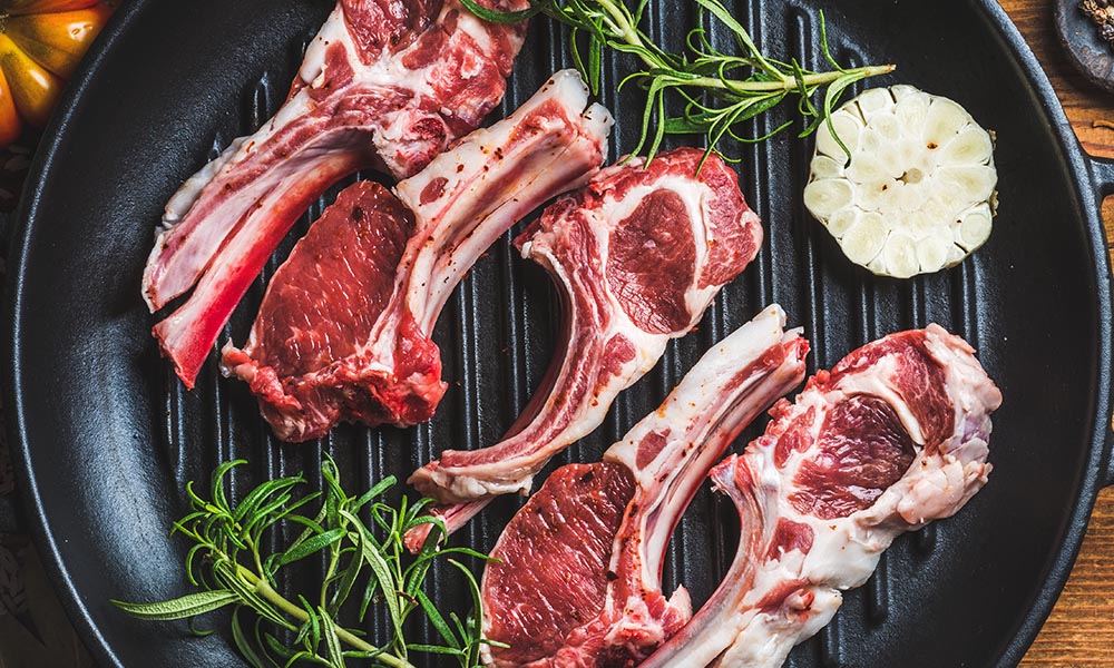 Lamb meat in a pan with herbs.