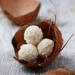 Keto no-bake coconut macaroons on a wooden surface.