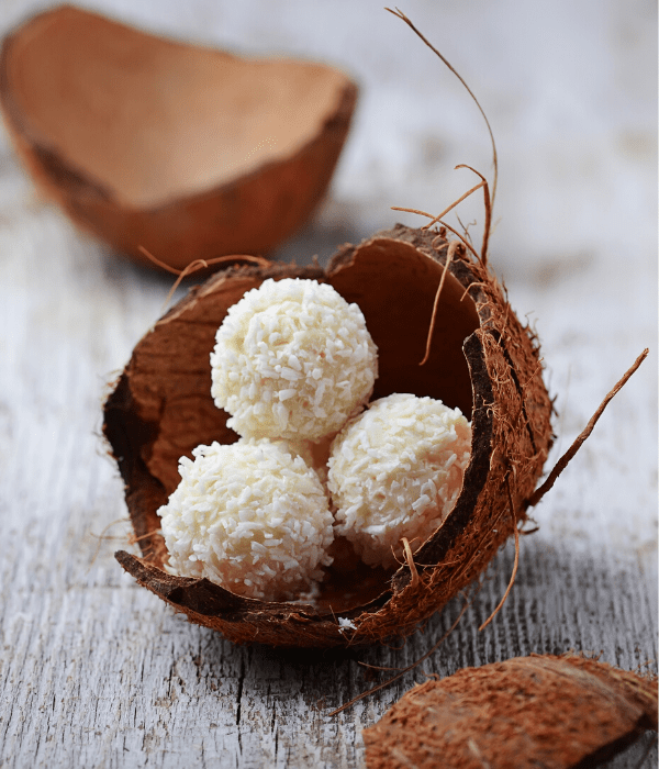 Keto no-bake coconut macaroons on a wooden surface.