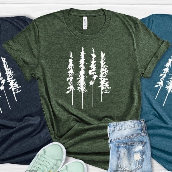 Three t-shirts with pine trees on them.
