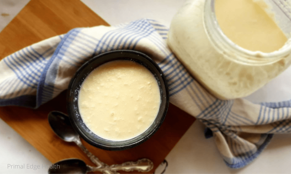 A bowl of homemade raw milk yogurt on a wooden board.