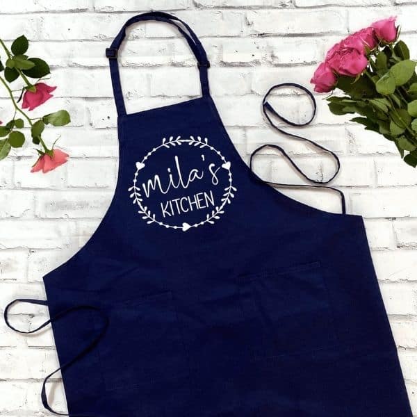 A navy apron with the word gillie's kitchen on it, perfect for preparing delicious recipes such as psyllium husk keto bread.