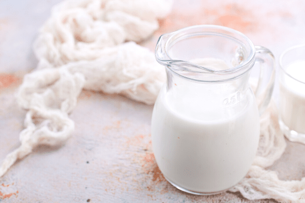 Raw milk in a glass pitcher.