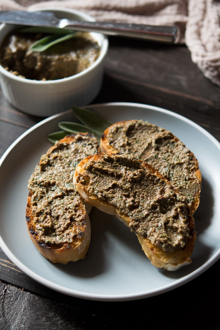 Three slices of bread with chicken liver pate on a plate.