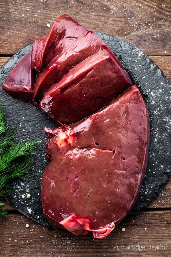 Raw beef liver on a cutting board.
