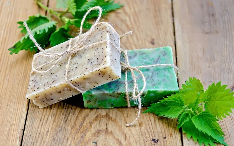 White and green tallow soaps on a wooden table.