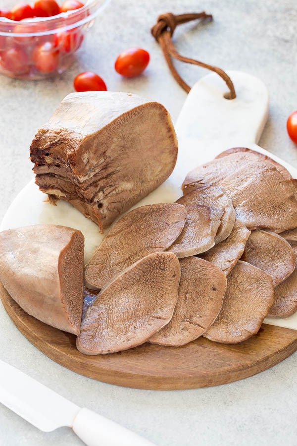 Slow-cooked beef tongue on a wooden board.