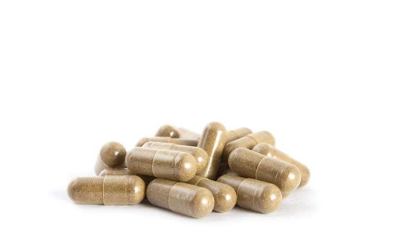 A stack of brown capsules on a white background.